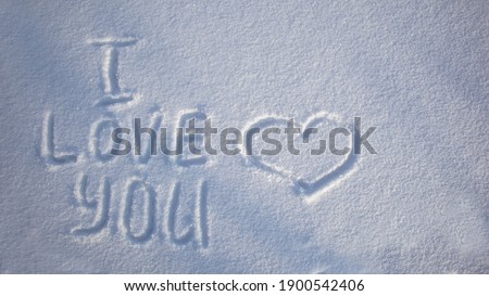 Love you lettering in the snow. Valentine's Day. The 14th of February. Valentine's day mood concept. Drawn heart in the snow. The inscription on the snow.