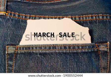 Text  March sale on white paper in the pocket of blue denim jeans. Can be use as marketing concept