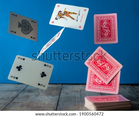 poker cards on a light blue background are flying in the air