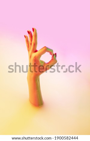 Nice, ok. Close up female hand gesturing from the milk bath with soft white glowing in neon light. Copyspace for advertising. Modern neoned colors, foam. Sales, symbols, urban style concept.