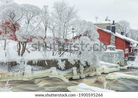 Waterfall in winter, strong current, frozen ice
  and trees in other. landscape photography
  Frost, ice, cold concept. Old town in Helsinki