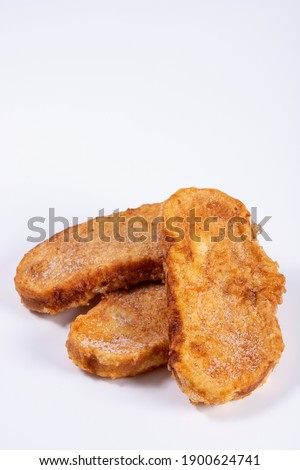 Fried bread with milk, egg, sugar and cinnamon (Torrijas). Typical Spanish Easter sweet. Vertical photography and selective focus