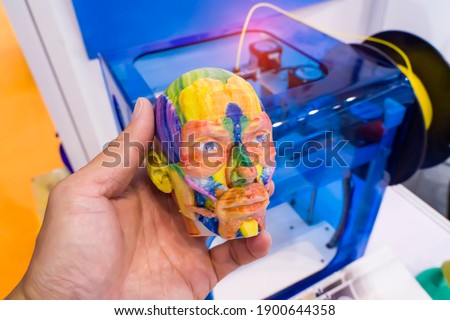 model printed on 3d printer in form of colorful muscles of the face with human hand,additive technologies and futuristic concept