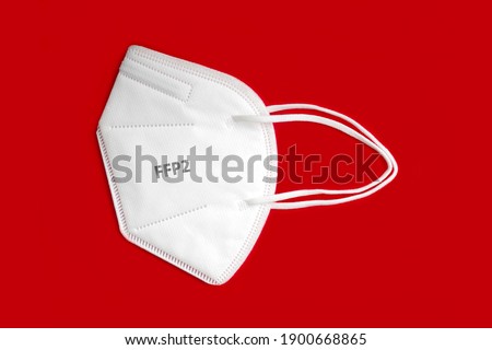 Side view of FFP 2 n95 protective face mask isolated on red background.