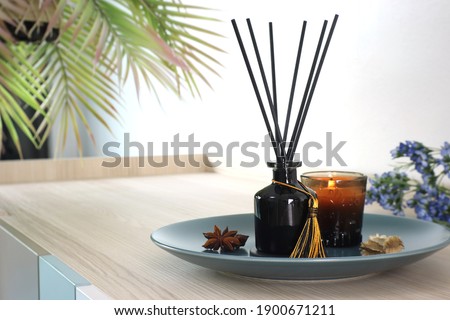 luxury aroma scent reed diffuser glass bottle is on the wooden table and amber glass of scented candle to creat romantic and relax ambient in the bedroom in the morning on happy valentine day Royalty-Free Stock Photo #1900671211