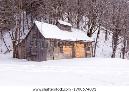 Small sugar shack in maple trees woods closed until spring seen during a grey winter afternoon on King’s Road, St-Augustin-de-Desmaures, Quebec, Canada Royalty-Free Stock Photo #1900674091