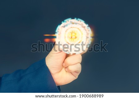 Businessman holds a gold bitcoin coin in his hands. Informational holographic panel with bright light effects. Virtual currency and blockchain concept
