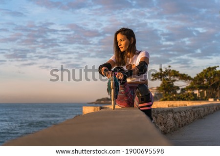 Woman sitting ready to skate early in the morning, fit lifestyle, skating concept.