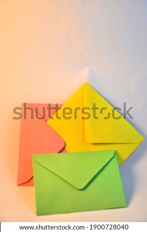 small open envelopes in yellow, pink, green colors