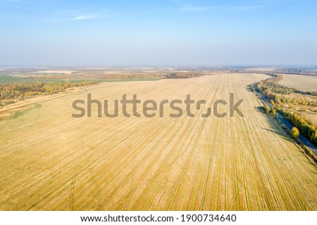 Aerial view of harvested agricultural fields and the highway in autumn day