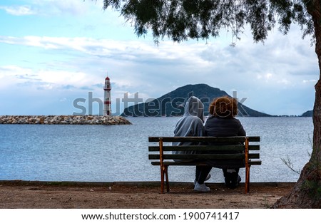 Tree bench and lighthouse by the sea.Turgutreis,Bodrum,Turkey