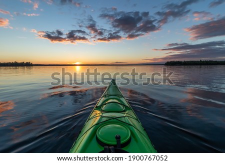 Kayaking at sunset on a calm lake in Northwest Ontario, Canada. Royalty-Free Stock Photo #1900767052