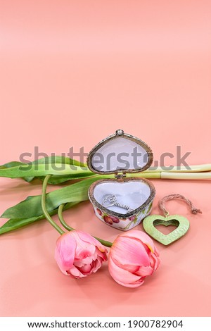 Valentine's Day tulips flowers with heart box and key to the heart. Image with tulips on pink background for Valentine's Day, International Women's Day, birthday and declaration of love postcards.