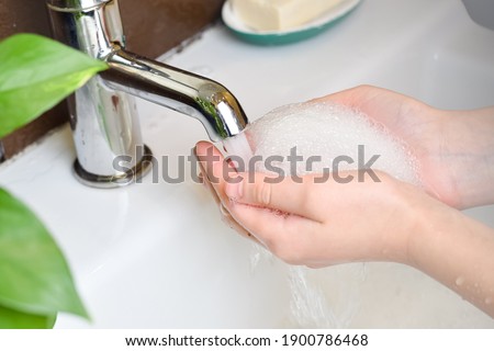 Child washing hands with soap and water. Hygiene concept. Protection against infections and viruses. Close up.