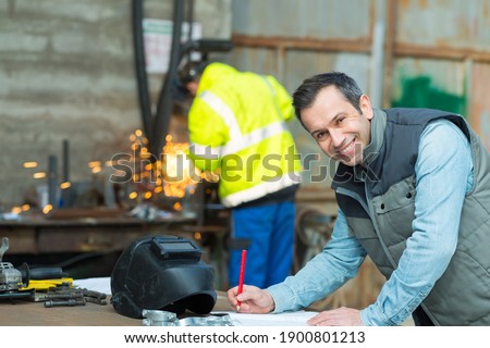 happy industrial steel welder worker at factory workshop