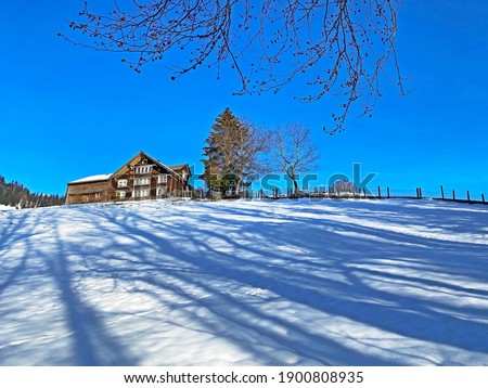 Idyllic Swiss alpine mountain huts and traditional Swiss rural architecture dressed in winter clothes and in a fresh snow cover in the Obertoggenburg region, Unterwasser - Switzerland (Schweiz)
