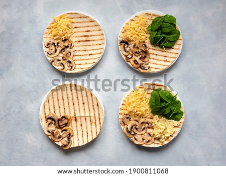 Tortillas with different fillings of mushrooms, cheese, spinach and fried egg. Food trend. Step by step photo instruction. Royalty-Free Stock Photo #1900811068