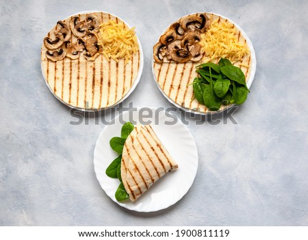 Tortillas with different fillings of mushrooms, cheese, spinach and fried egg. Food trend. Royalty-Free Stock Photo #1900811119