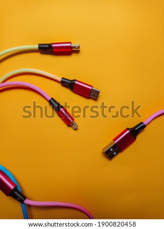 Bright color usb charging wire with three universal connectors on yellow background