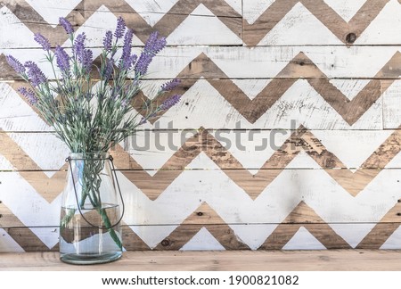Farmhouse vase of lavender with a wooden natural and white chevron print background