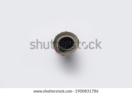 Money rolled up in a tube on a light white background. Banner. Flat lay, top view.