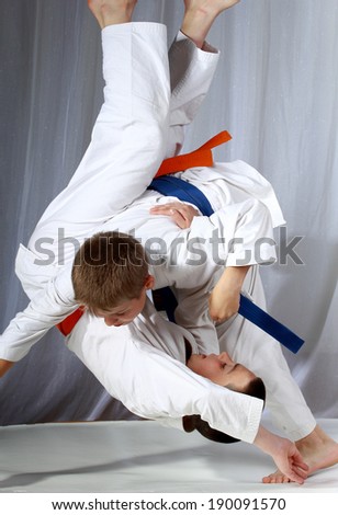 Sportsman in judogi and with blue belt is doing throw Royalty-Free Stock Photo #190091570