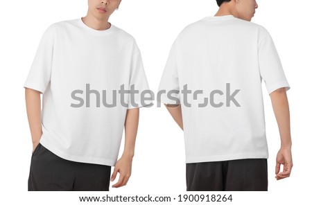 Young man in blank oversize t-shirt mockup front and back used as design template, isolated on white background with clipping path. Royalty-Free Stock Photo #1900918264