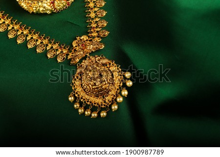 Amazing Antique Gold Jewelry placed on green silk cloth picture. Royalty-Free Stock Photo #1900987789