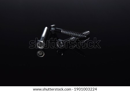 Big metal screw on black background