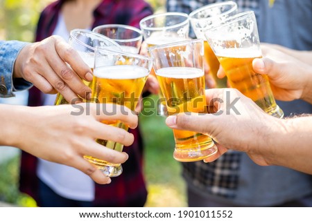 A group of friends cheered the beer and laughed happily on the holidays. Royalty-Free Stock Photo #1901011552