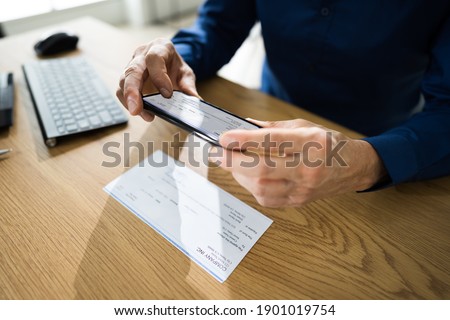 Remote Check Deposit Taking Photo With Mobile Phone Royalty-Free Stock Photo #1901019754