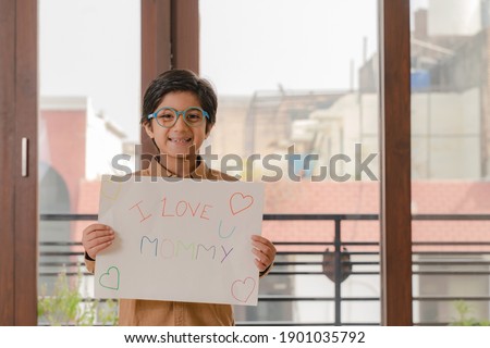 Little boy holding poster on mother's day 