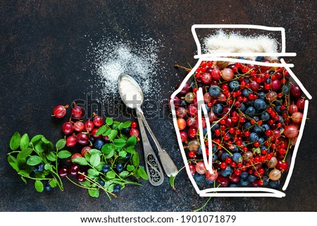 Various berries in the form of a jar on a dark background. Top view.