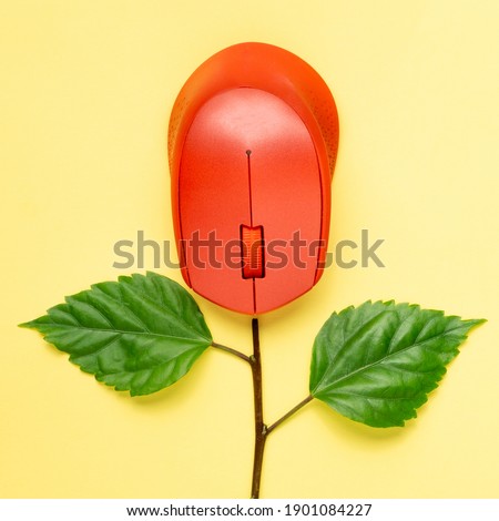 Creative concept a red computer mouse with a flower branches. Flat lay. Square size of photo.
