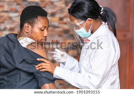 medical personnel administers a vaccine to a patient Royalty-Free Stock Photo #1901093155