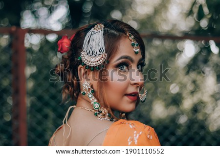 Beautiful Indian, Asian lady with traditional wedding dress-orange and red color-jewelry