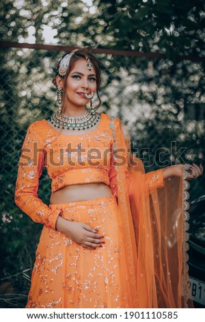 Beautiful Indian, Asian lady with traditional wedding dress-orange and red color-jewelry