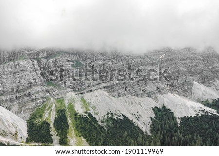 Aerial drone shot of rock cliff of Zugspitze covered with heavy fog in Germany