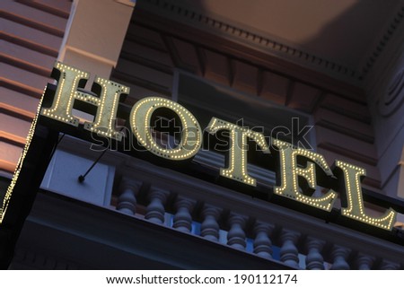 Illuminated hotel sign on the wall of building