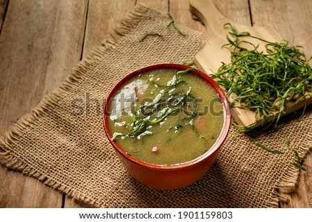green broth with pepperoni and cabbage with top view on rustic wooden table