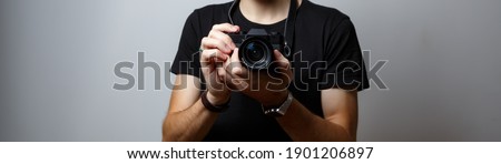 A small camera in the hands of a photographer.