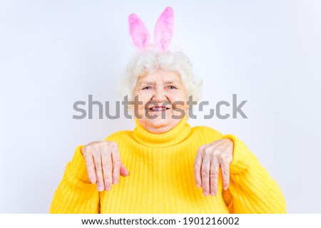 european senior pensioner with bunny ears in studio wall
