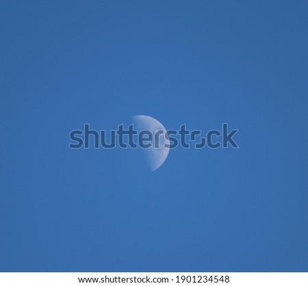 Clear blue sky with visible moon during the day. 