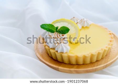 Lemon Tart citrus cake in wood dish and white cloth background, cake and bakery concept