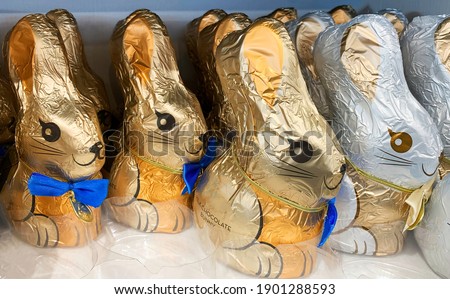 Chocolate bunnies on a shelf in a supermarket. Brightly coloured foil rapped gifts for Easter holiday. High quality photo