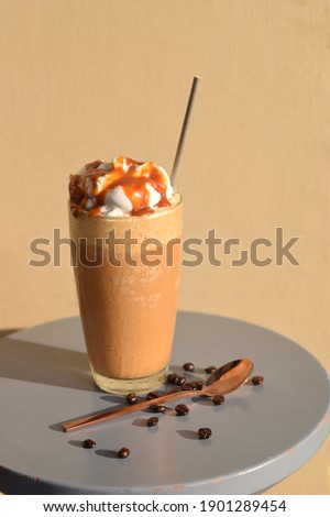 Iced caramel macchiato coffee in glass with stainless steel spoon on table Royalty-Free Stock Photo #1901289454