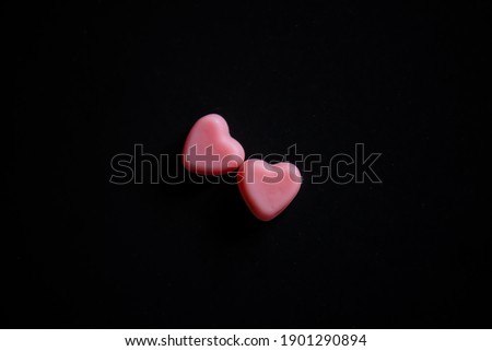 Two small hearts on the black background. Valentine`s day concept