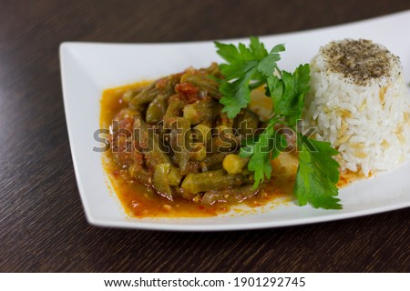 Okra with rice pilaf and parsley in a white plate