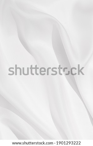 Cloth texture background white colors. Bright satin fabric with creases on fabric close up.  Hard light and top view.