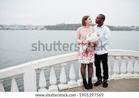 Happy multiethnic couple in love story. Relationships of african man and white european woman. 